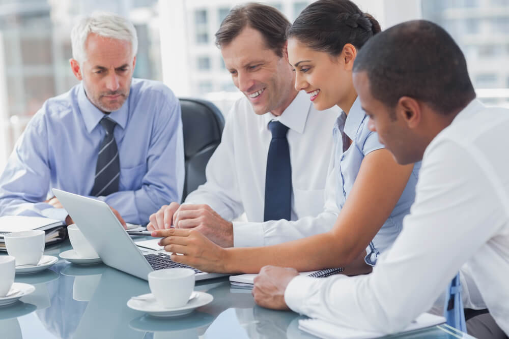 Business people looking at a laptop during a meeting