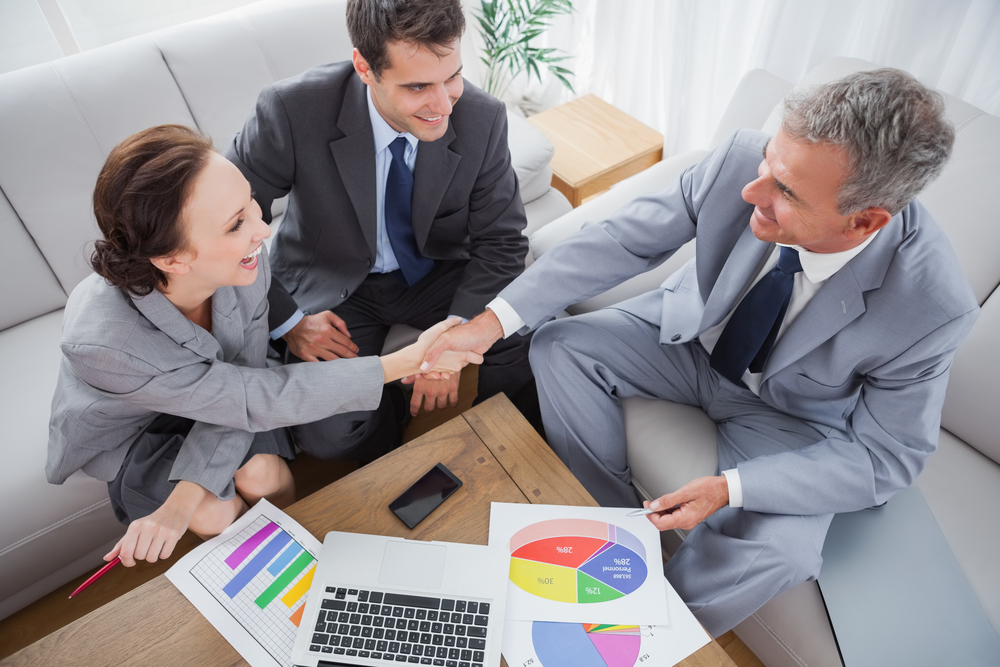 Business people shaking hands while working in cosy meeting room