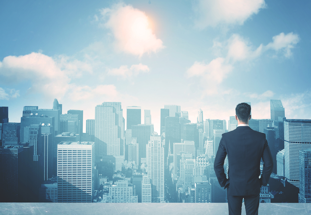 Businessman%20standing%20on%20a%20roof%20and%20looking%20at%20future%20city