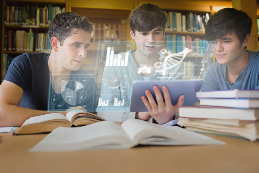 Concentrated young men studying medicine together with futuristic interface in university library