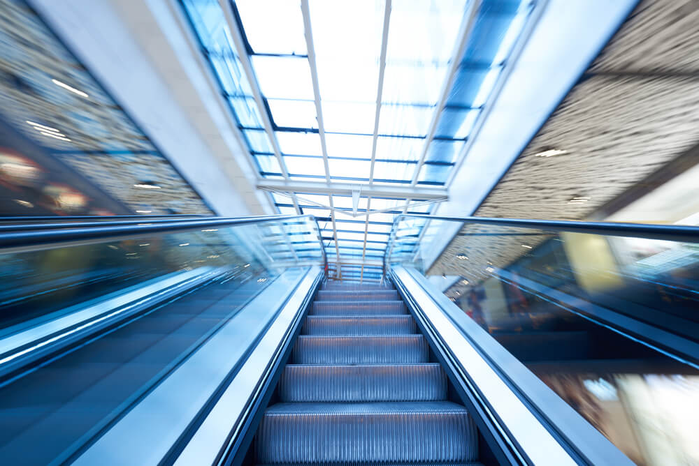 Shopping mall center escalators. Zoom blur movement.